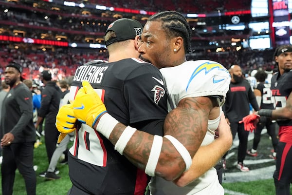 Los Angeles Chargers safety Derwin James Jr. (3) hugs Atlanta Falcons quarterback Kirk Cousins (18) after an NFL football game on Sunday, Dec. 1, 2024 in Atlanta. (AP Photo/Mike Stewart)