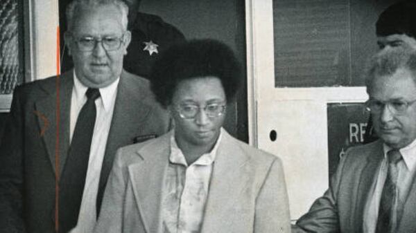 Law officials escort Wayne Williams from the Fulton County Jail in 1981 on his way to a commitment hearing before Fulton County State Court Judge Albert Thompson. Heavy security was in effect for the hearing, weapons searches mandated for all those entering the courtroom, except sheriff's deputies. (Andy Sharp / AJC file)