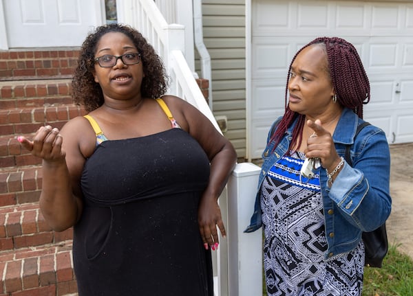 Ebon Sledge (left) talks with Cherie DeBose, program coordinator with Opens Doors, who helped Sledge get their new rental home for her and her eight children. PHIL SKINNER FOR THE ATLANTA JOURNAL-CONSTITUTION