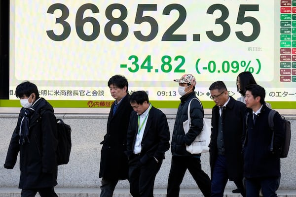 People walk in front of an electronic stock board showing Japan's Nikkei index at a securities firm Monday, March 10, 2025, in Tokyo. (AP Photo/Eugene Hoshiko)