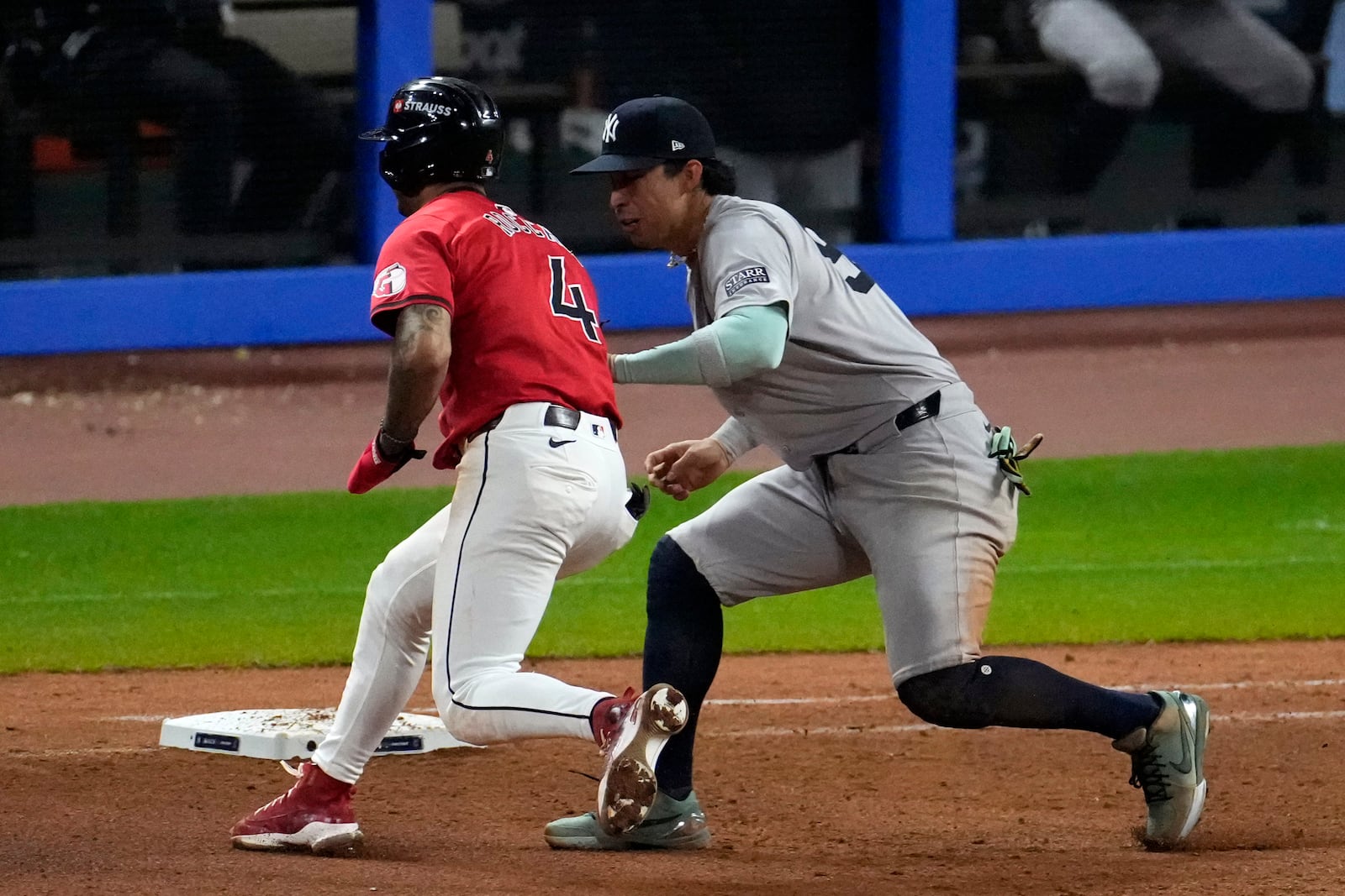 New York Yankees first baseman Oswaldo Cabrera, right, tags out Cleveland Guardians' Brayan Rocchio (4) during the seventh inning in Game 5 of the baseball AL Championship Series Saturday, Oct. 19, 2024, in Cleveland. (AP Photo/Jeff Roberson)