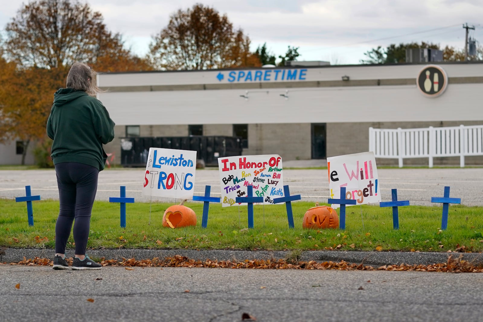 FILE - A woman visits a makeshift memorial outside Sparetime Bowling Alley, the site of a mass shooting, Oct. 28, 2023, in Lewiston, Maine. (AP Photo/Robert F. Bukaty, File)