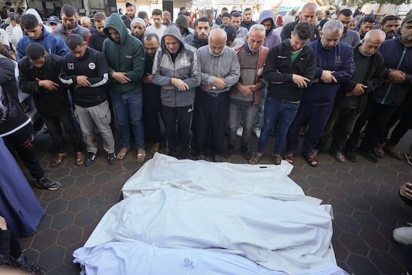 Men pray over the bodies of victims from an Israeli airstrike outside a hospital in Deir al-Balah, Gaza, Sunday Nov. 17, 2024. Palestinian medical officials reported Sunday that Israeli strikes overnight killed 12 people in Central Gaza. One child and five women were counted among them.(AP Photo/Abdel Kareem Hana)