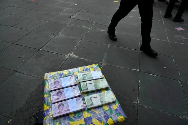 Iranian banknotes are displayed by a street money exchanger at Ferdowsi square, Tehran's go-to venue for foreign currency exchange, in downtown Tehran, Iran, Wednesday, Dec. 18, 2024. (AP Photo/Vahid Salemi)