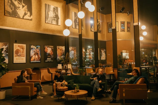 Moviegoers mingle in the lobby of the Tara Theatre in Atlanta as they wait for a showing of Anora to begin on Friday, March 7, 2025. (Olivia Bowdoin for the AJC). 