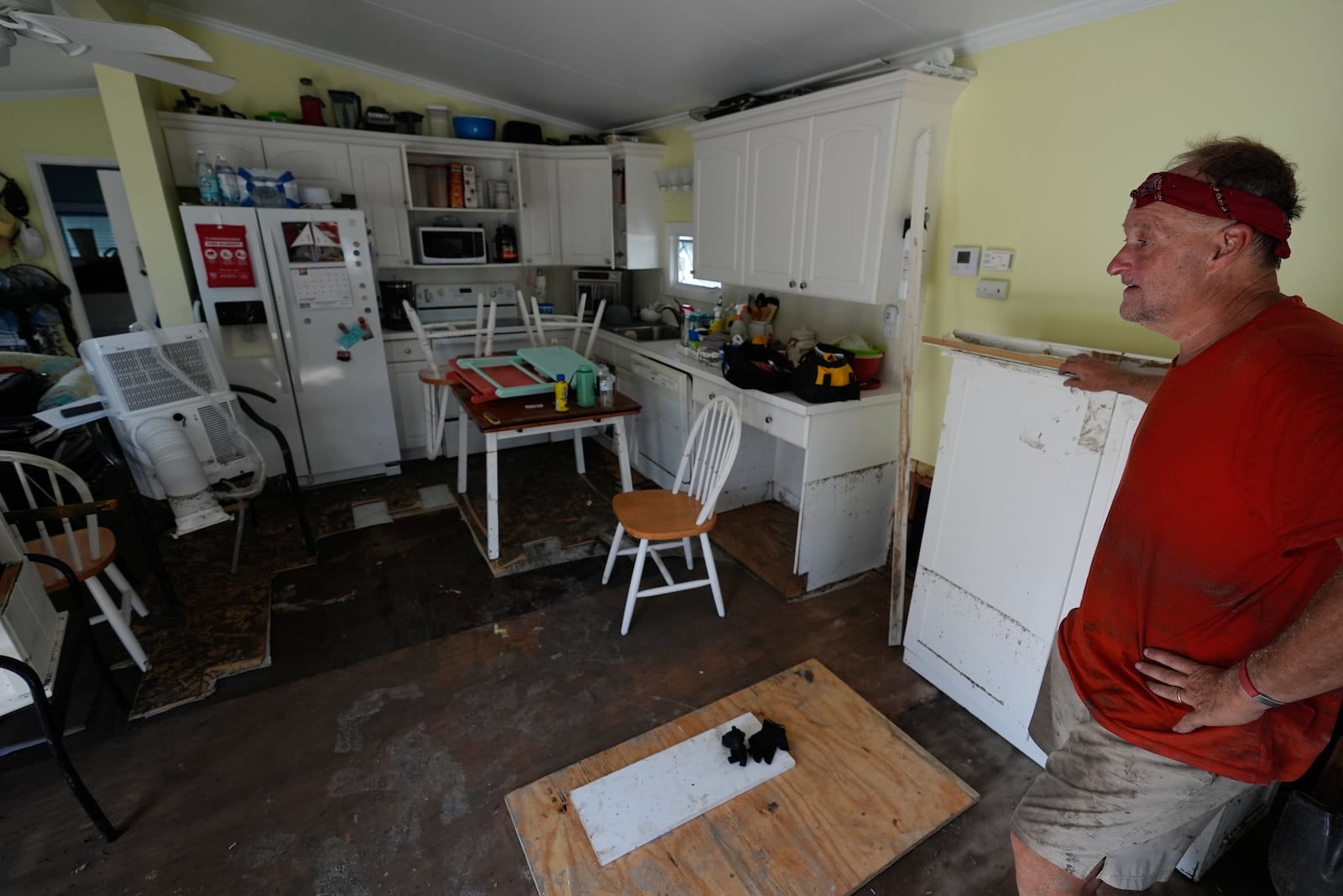 Jim Beeson, a board member of Gulf to Bay Co-Op 55+ mobile home community, looks at damage left by flooding during Hurricane Milton, on Manasota Key, in Englewood, Fla., Sunday, Oct. 13, 2024. (AP Photo/Rebecca Blackwell)