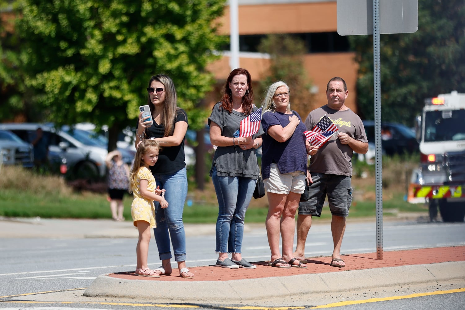 People stand by Chastain Rd to pay respect to fallen Deputy Jonathan Koleski during the procession on Wednesday, September 14, 2022. Miguel Martinez / miguel.martinezjimenez@ajc.com