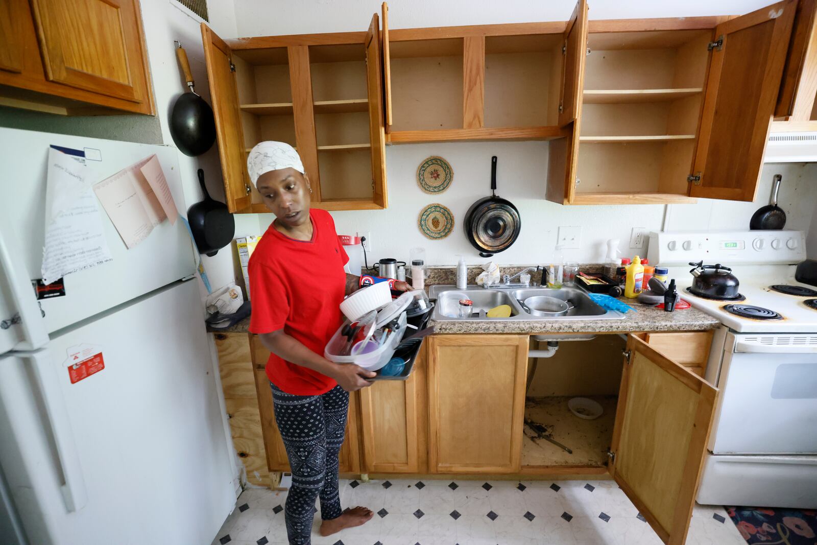 Pavilion Place tenant Danielle Russell washes her cookware to keep it clean from vermin that infested her southwest Atlanta apartment. This summer, she stored it inside plastic bags in the living room as she waited for an exterminator to complete deep treatments, but he failed to arrive for a second visit. (Miguel Martinez/miguel.martinezjimenez@ajc.com)