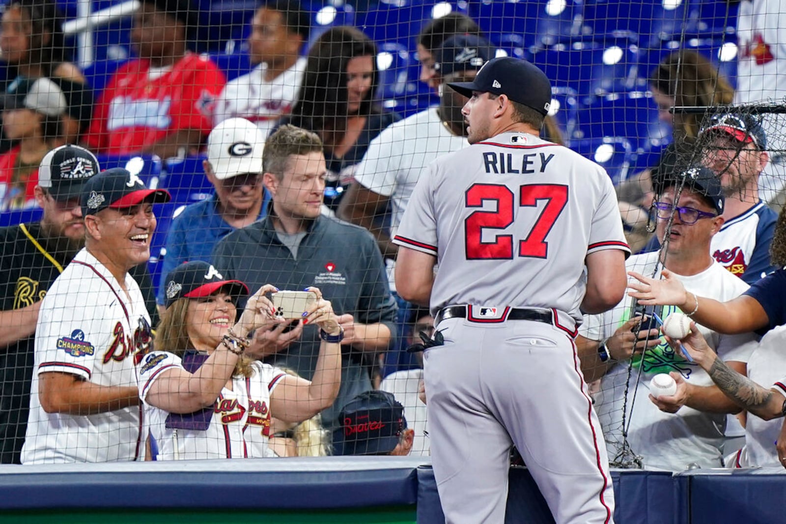 Atlanta Braves third baseman Austin Riley (27) signs autographs before the start of a baseball game against the Miami Marlins, Friday, Aug. 12, 2022, in Miami. (AP Photo/Wilfredo Lee)