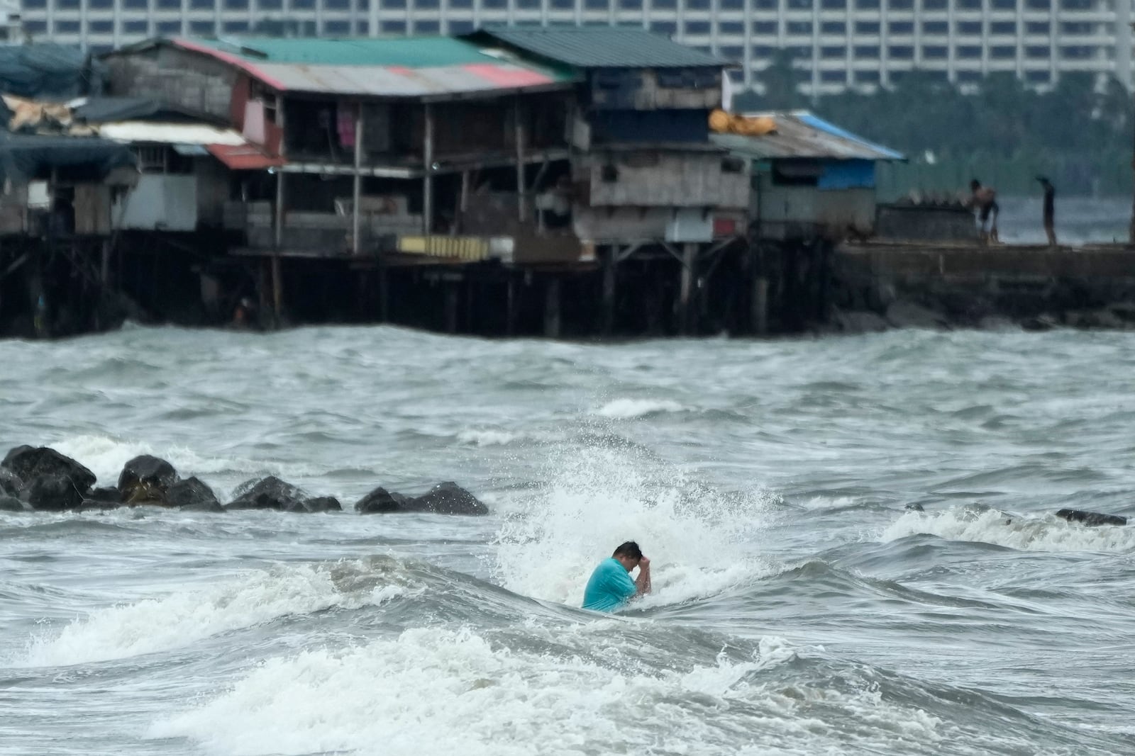 A resident swims despite the strong waves caused by Tropical Storm Trami in Manila, Philippines Wednesday, Oct. 23, 2024. (AP Photo/Aaron Favila)