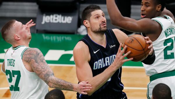 Orlando Magic's Nikola Vucevic (9) drives past Boston Celtics' Daniel Theis (27) and Semi Ojeleye (37) during the second half on an NBA basketball game, Sunday, March 21, 2021, in Boston. (AP Photo/Michael Dwyer)