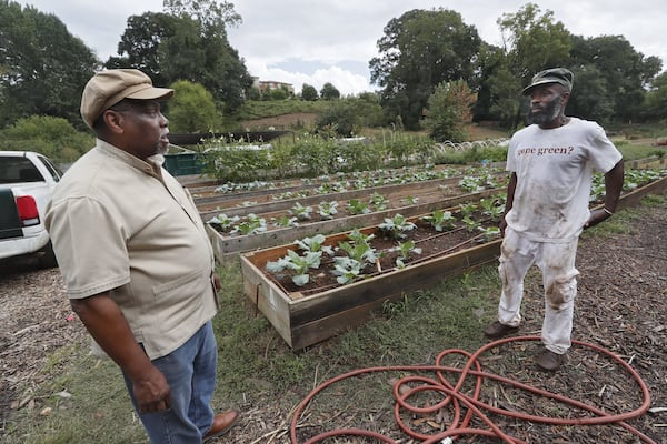 On a visit to the Truly Living Well urban farm in Atlanta, K. Rashid Nuri (left) talks with Ras Kofi, who was working in the garden. Nuri is known as the elder statesman of Atlanta’s urban gardening. 