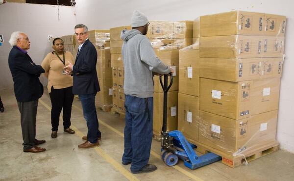 (left to right) Chairman of the Elections Board Samuel Tillman, Director of Voter Registration and Elections Erica Hamilton and Secretary of State Brad Raffensperger talks as Kentavious Ford unloads a pallet from a shipment of Georgia’s new secure paper-ballot voting machines at the Dekalb County Voter Registration and Elections offices in Avondale Estates on Monday December 30, 2019. (Photo by Phil Skinner).