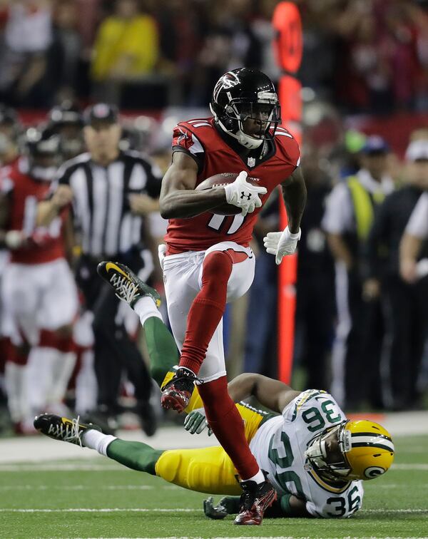 FILE - In this Jan. 22, 2017, file photo, Atlanta Falcons' Julio Jones catches a touchdown pass in front of Green Bay Packers' LaDarius Gunter during the second half of the NFL football NFC championship game, in Atlanta. Atlanta led the NFL in points (540) by a wide margin, thanks to a career year from QB Matt Ryan (2), who along with WR Julio Jones (11) are All-Pros. The Falcons (13-5) take on the New England Patriots (16-2) in Super Bowl LI in Houston on Feb. 5, 2017. (AP Photo/David Goldman, File)