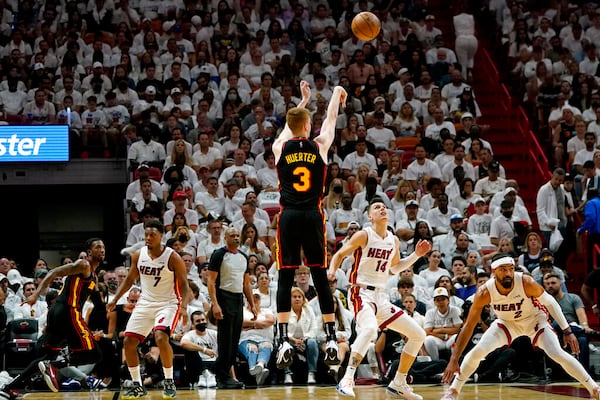 Atlanta Hawks guard Kevin Huerter (3) shoots over Miami Heat guard Tyler Herro (14) and guard Gabe Vincent (2) during the first half of Game 2 of an NBA basketball first-round playoff series, Tuesday, April 19, 2022, in Miami. (AP Photo/Lynne Sladky)