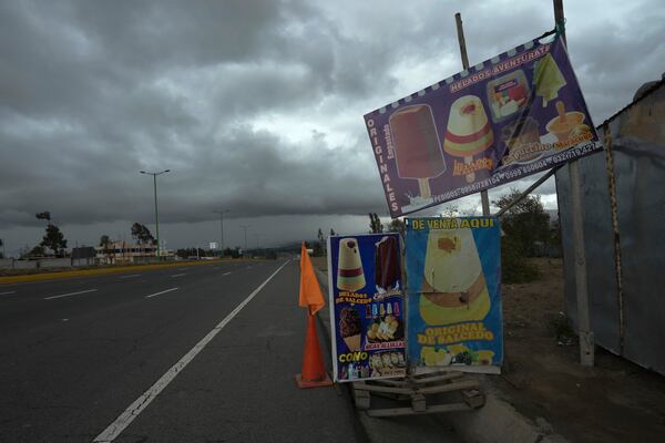 Signs advertise Salcedo's creamy popsicles along the Pan-American highway, in Latacunga, Ecuador, Thursday, Nov. 28, 2024, amid a wave of power outages, triggered by a prolonged dry spell. (AP Photo/Dolores Ochoa)