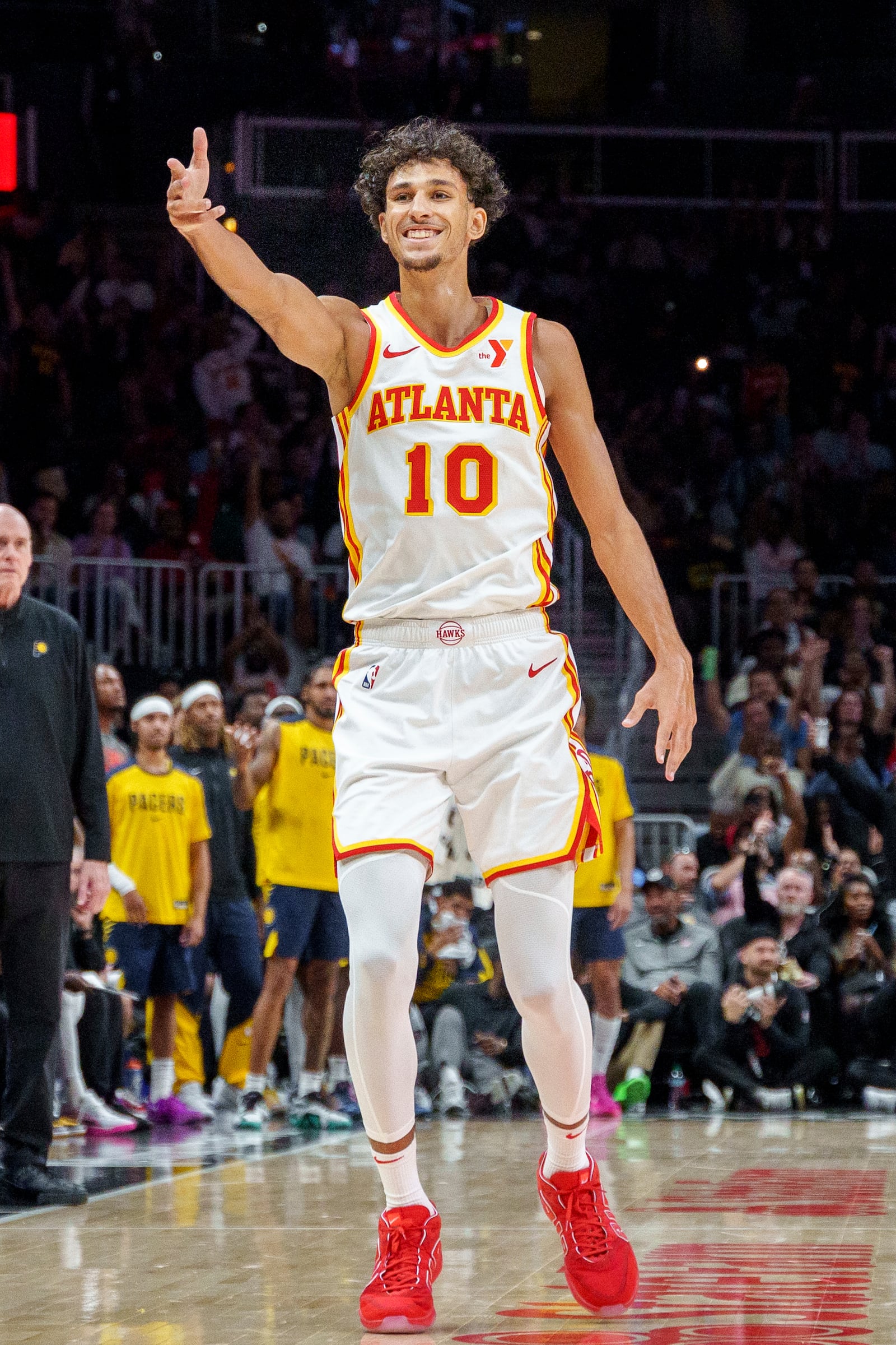 Atlanta Hawks forward Zaccharie Risacher (10) gestures towards the Hawks' bench after making a three-pointer during the second half of a preseason NBA game against the Indiana Pacers, Tuesday, Oct. 8, 2024, in Atlanta. (AP Photo/Jason Allen)