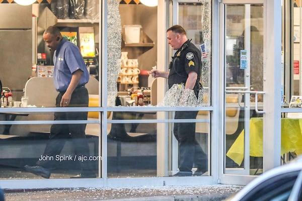 Glass is shattered near the seating area of the Waffle House in the 1000 block of Northside Drive. JOHN SPINK / JSPINK@AJC.COM