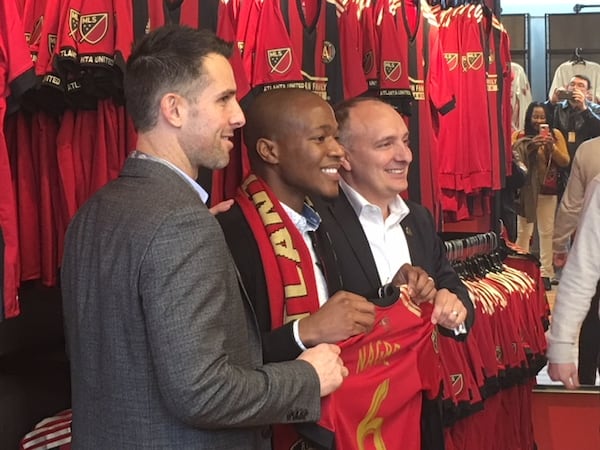 Atlanta United Vice President Carlos Bocanegra (left) and President Darren Eales (right) pose with Darlington Nagbe in December.