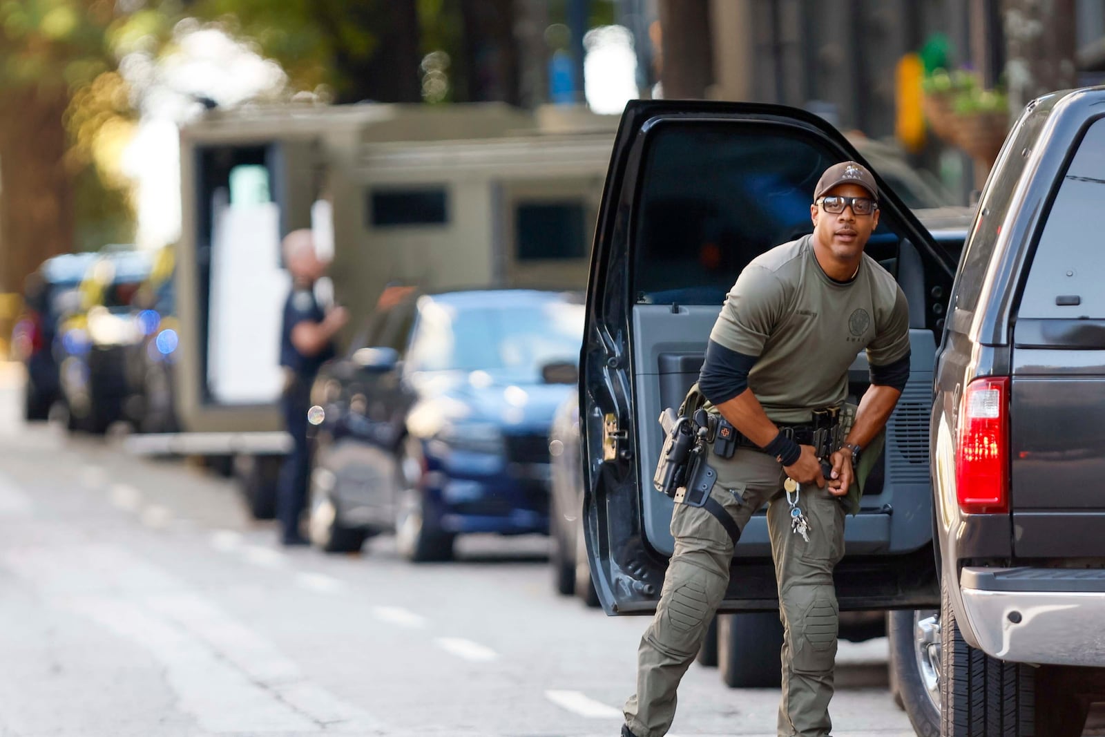 A SWAT team member adjusts his weapon on 14th Street outside the Four Seasons Hotel in the Midtown neighborhood of Atlanta, where a suspect fired shots inside the hotel Tuesday, Oct. 29, 2024. (Miguel Martinez/Atlanta Journal-Constitution via AP)