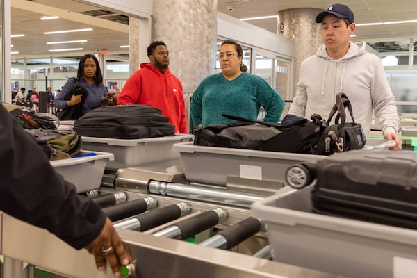 Travelers pass through a newly reopened lane during a security screening in the domestic terminal at Hartsfield-Jackson in Atlanta on Thursday, December 14, 2023. (Arvin Temkar / arvin.temkar@ajc.com)