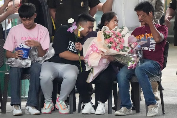 CORRECTS TO FAMILY INSTEAD OF SON AND HUSBAND - Mary Jane Veloso, second from right, a Filipino woman who spent almost 15 years in an Indonesian prison for drug trafficking and was nearly executed by firing squad in 2015, is reunited with her family as she arrives at the Correctional Institution for Women in Mandaluyong, Philippines Wednesday, Dec. 18, 2024. (AP Photo/Aaron Favila)