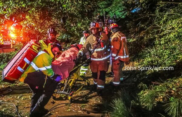 Atlanta fire crews worked for about 40 minutes to free a man trapped in his third-floor bedroom after a tree came crashing down on a home on Brookview Drive.