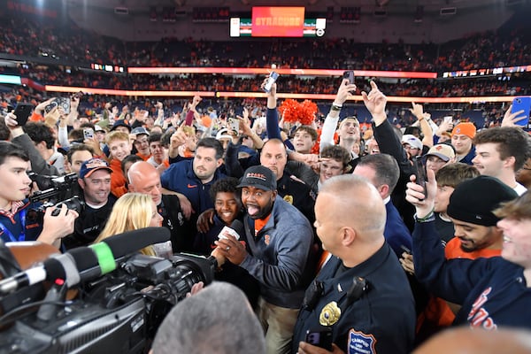 Syracuse head coach Fran Brown, center, reacts while being interviewed after his team's win over Miami in an NCAA college football game Saturday, Nov. 30, 2024, in Syracuse, N.Y. (AP Photo/Adrian Kraus)