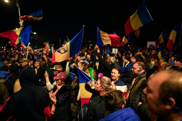 Supporters of Calin Georgescu react during a protest after Romania's Constitutional Court upholded a ban on his candidacy in the presidential election rerun, in Bucharest, Romania, Tuesday, March 11, 2025. (AP Photo/Vadim Ghirda)