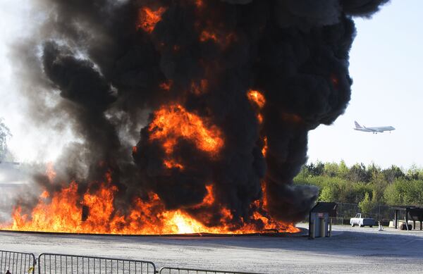 A plans lands behind a huge fireball as Hartsfield-Jackson International Airport held a full-scale disaster drill with Atlanta Firefighters, law enforcement, rescue personnel and nearly 150 volunteers who participated in a triennial exercise known as âBig Birdâ on Thursday, April 12, 2018. Airport personnel mobilized to a mock aircraft crash, extinguished the fire then triaged & treated the victims at a training site. The Federal Aviation Administration requires airports to conduct annual emergency preparedness drills and at least one full-scale drill every three years. (Photo by Phil Skinner)NOTE: getting Ids was impossible because the media was too far away.