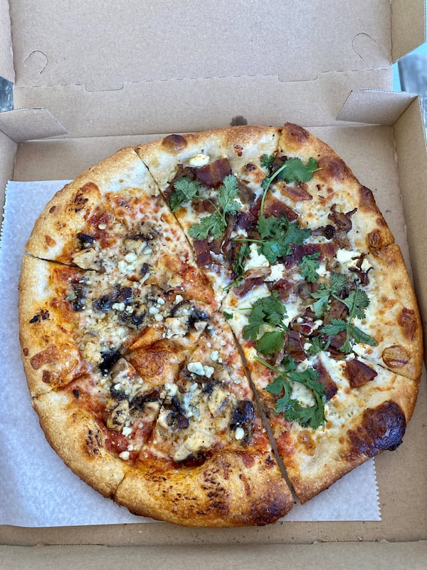 This half-and-half pie from Dolos Pizza is half a Matey pizza (marinara, mozzarella, jerk chicken, blue cheese and honey) and half a Mr. Rager (garlic crema, bacon, mushrooms, goat cheese, cilantro). Wendell Brock for The Atlanta Journal-Constitution