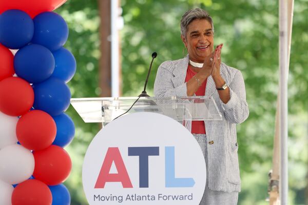 Camille Russell Love, executive director of the Mayor's Office of Cultural Affairs, applauds during the ceremony for the new statue and mural in honor of Hank Aaron at the Adams Park baseball complex, Thursday, August 4, 2022, in Atlanta. (Jason Getz / Jason.Getz@ajc.com)