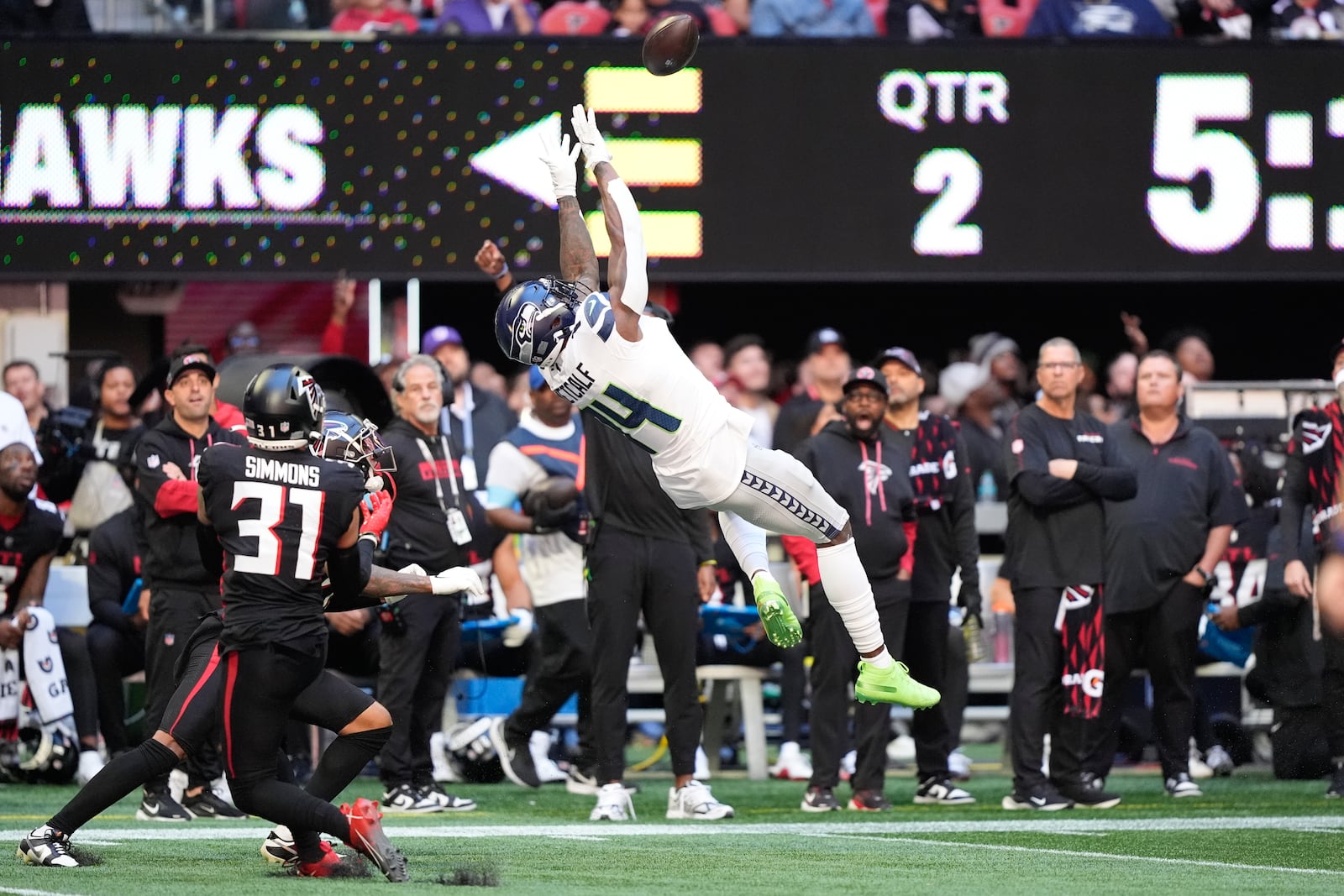 Seattle Seahawks wide receiver DK Metcalf (14) makes a catch as Atlanta Falcons safety Justin Simmons (31) defends during the first half of an NFL football game, Sunday, Oct. 20, 2024, in Atlanta. (AP Photo/ Brynn Anderson )