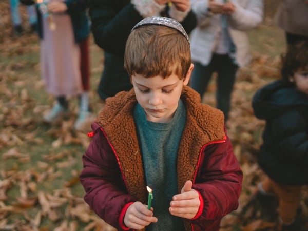 A boy holds a candle during the lighting of the menorah ceremony at Atlantic Station. (Courtesy of Atlantic Station)