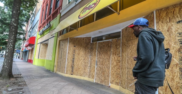 Businesses in Atlanta along Peachtree Street across from Woodruff Park were boarded up on Monday, June 1, 2020, after losing glass to vandals. Over the weekend vandals left a trail of smashed windows and graffiti in their wake as protests against police brutality continued across the country. JOHN SPINK/JSPINK@AJC.COM