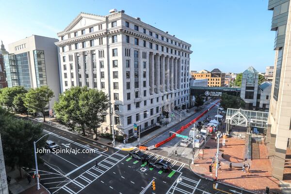 Fulton County sheriff's deputies and a stable of television news crews wait outside the Fulton County courthouse Monday as prosecutors began presenting their election interference case against former President Donald Trump and others.