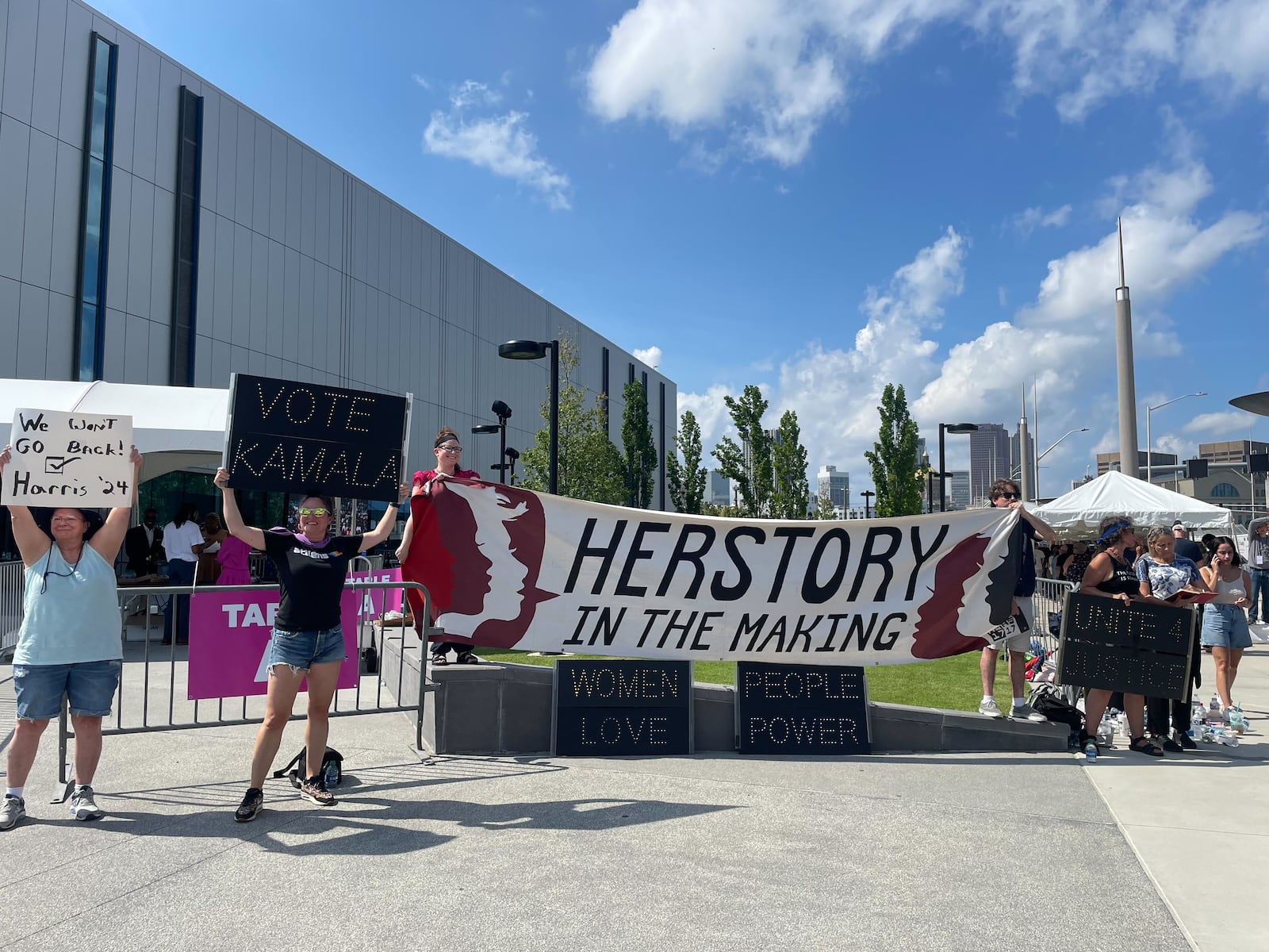 A group of Kamala Harris supporters gathered at the entrance of the rally in Atlanta on Tuesday, July 30, 2024, with a banner that read “Herstory in the making.” (Photo: Riley Bunch / AJC)