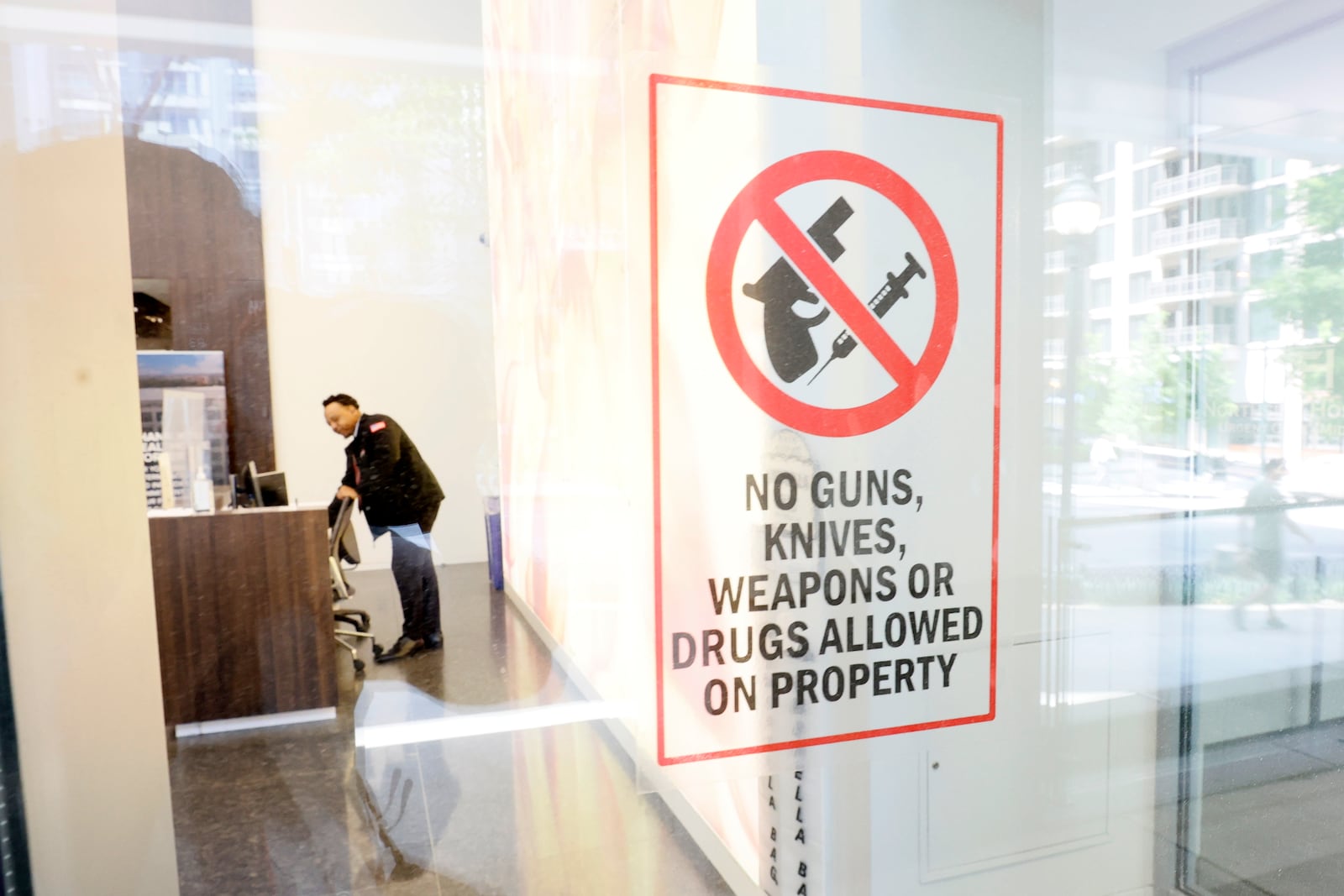 Security personnel is seen working by the Northside Hospital medical building entrance in Midtown Atlanta on Thursday, May 4, 2023. A small sign shows that no weapons are allowed in the building where a gunman killed one person the previous day and injured four more. 
Miguel Martinez /miguel.martinezjimenez@ajc.com