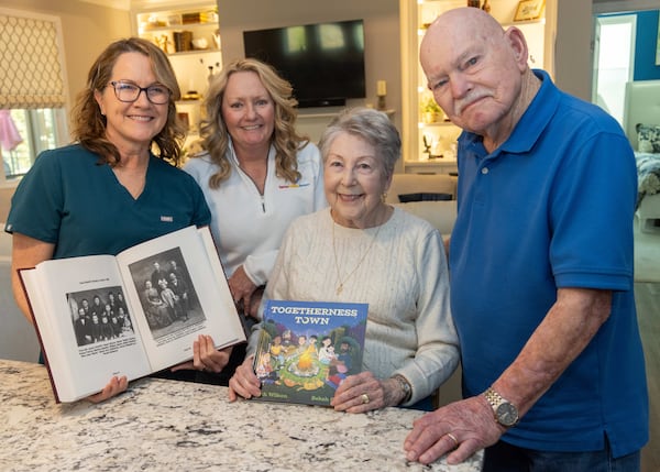 Beth Wilson (from left), Tina Boggs and Ruth and Bill Renner show off their books at the Renners' Gainesville home. Wilson is holding Bill Renner's genealogy book while Ruth Renner holds Wilson's new book. Wilson brought her first published children's book to the Renners' home on release day, and they were her first buyers. PHIL SKINNER FOR THE ATLANTA JOURNAL-CONSTITUTION