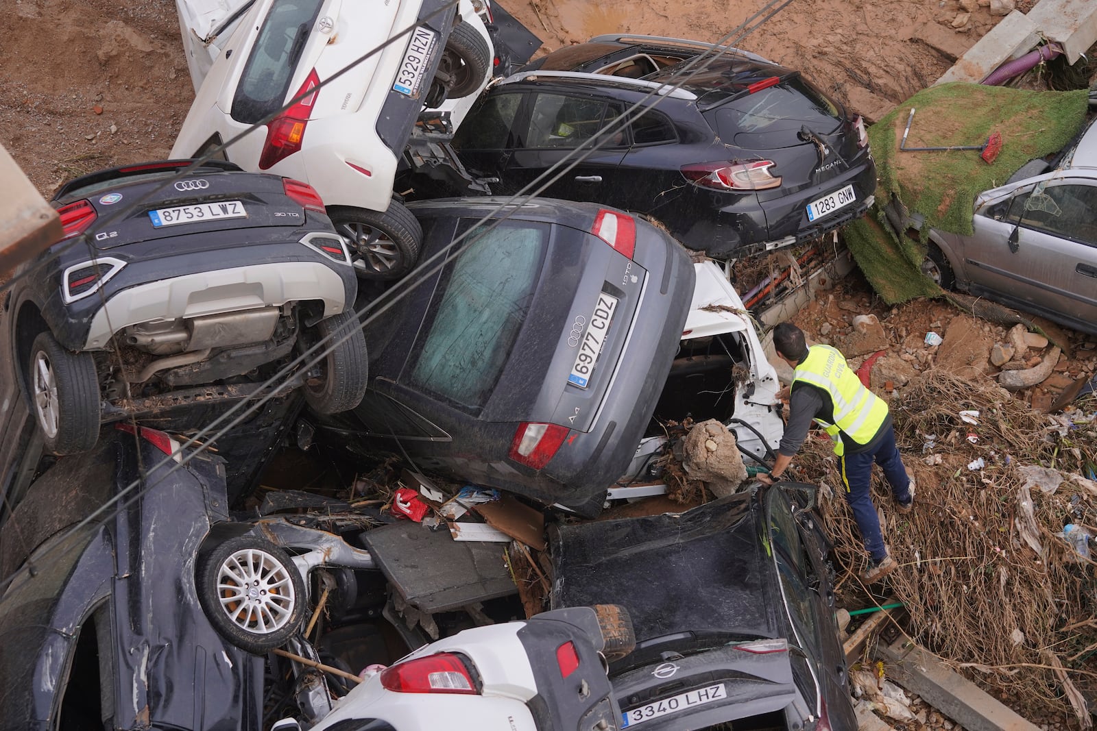 A civil guard seaches for survivors in cars piled up on the outskirts of Valencia, Spain, Friday, Nov. 1, 2024 after flooding. (AP Photo/Alberto Saiz)