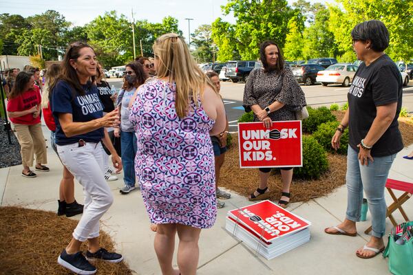 Cobb County community members gather outside of the school district office in Marietta, Georgia, on May 20, 2021, to show their opposition to students wearing masks. Many community members waited in line to speak at the school board meeting to voice their support for unmasking.  (CHRISTINA MATACOTTA FOR THE ATLANTA JOURNAL-CONSTITUTION)