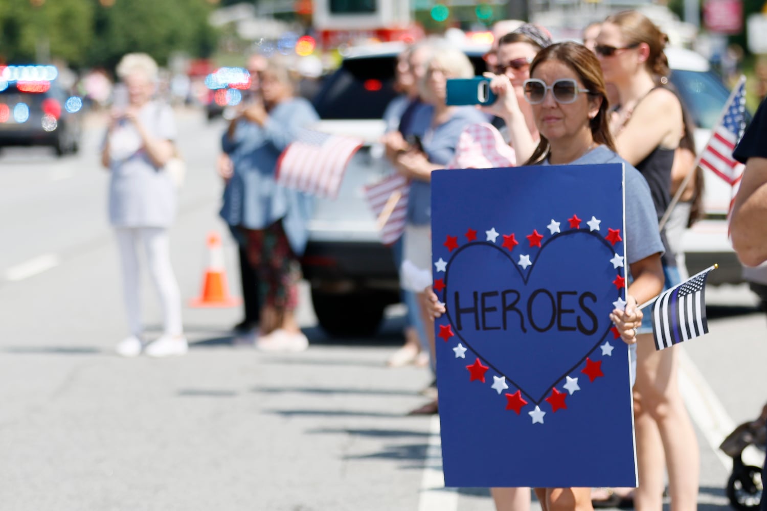 Sandra Peterson from Flowery Branch, who has a son in law enforcement, holds a sign in support as the procession of fallen Deputy Jonathan Koleski passes over Chastain Road in Kennesaw on Wednesday, September 14, 2022. Wednesday, September 14, 2022. Miguel Martinez / miguel.martinezjimenez@ajc.com