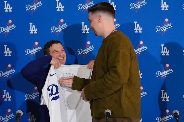 Los Angeles Dodgers pitcher Blake Snell, right, is presented with a jersey by president of baseball operations Andrew Friedman during a news conference Tuesday, Dec. 3, 2024, in Los Angeles. (AP Photo/Jae C. Hong)