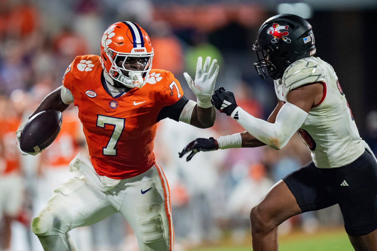 Clemson running back Phil Mafah (7) runs with the ball while pursued by Louisville defensive back M.J. Griffin (26) in the second half of an NCAA college football game Saturday, Nov. 2, 2024, in Clemson, S.C. (AP Photo/Jacob Kupferman)