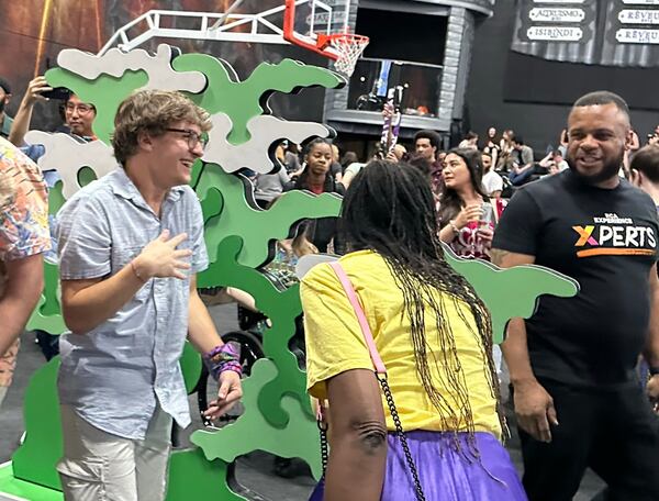 Carson Garrett (left), a Georgia Tech student and "Survivor 44" contestant, performed several puzzle challenges at Ron Clark's "Survivor" party April 12, 2023 at Ron Clark Academy. RODNEY HO/rho@ajc.com