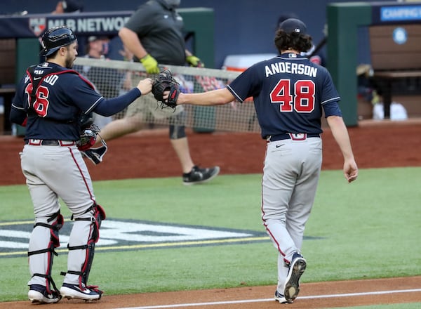 Braves starting pitcher Ian Anderson fist-bumps catcher Travis d'Arnaud after getting out of a bases loaded jam in the third inning of Game 2 of the National League Championship Series against the Los Angeles Dodgers Tuesday, Oct. 13, 2020, at Globe Life Field in Arlington, Texas. (Curtis Compton / Curtis.Compton@ajc.com)



