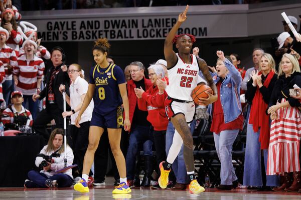 NC State's Saniya Rivers (22) celebrates ahead of Notre Dame's Cassandre Prosper (8) in the final moments of an NCAA college basketball game in Raleigh, N.C., Sunday, Feb. 23, 2025. (AP Photo/Ben McKeown)