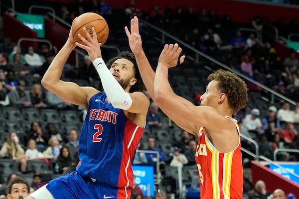 Detroit Pistons guard Cade Cunningham (2) is defended by Atlanta Hawks guard Dyson Daniels during the first half of an NBA basketball game, Friday, Nov. 8, 2024, in Detroit. (AP Photo/Carlos Osorio)