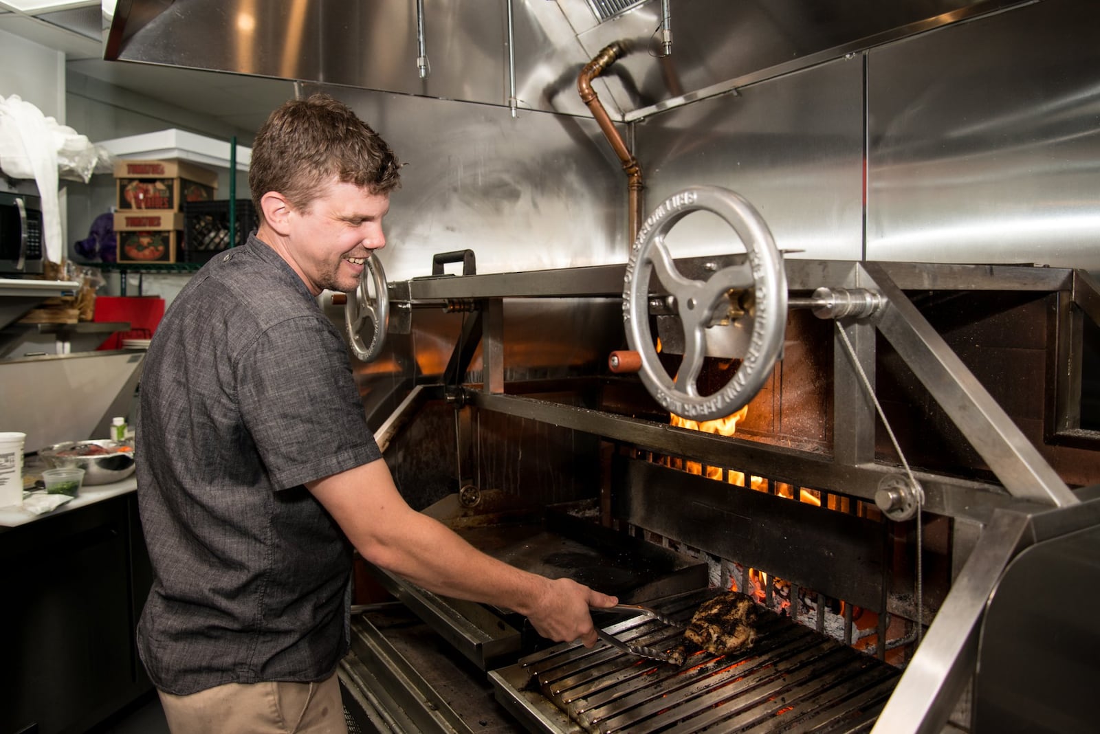 Executive Chef Woolery "Woody" Back uses the custom wood-fired grill for multiple dishes at Coalition. Photo credit- Mia Yakel.