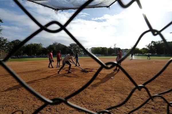 A teenage baseball player grooms the field during a daily training session at the Trinitarios ballpark in Santo Domingo, Dominican Republic, Wednesday, Feb. 5, 2025. (AP Photo/Ricardo Hernandez)